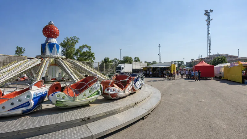 Atracción familiar y puestos en un recinto ferial bajo el sol