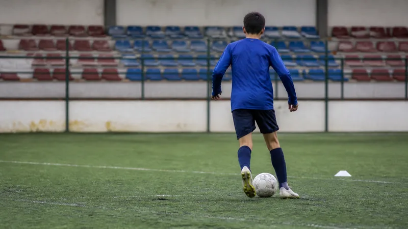 Futbolista juvenil visto de espaldas durante un entrenamiento