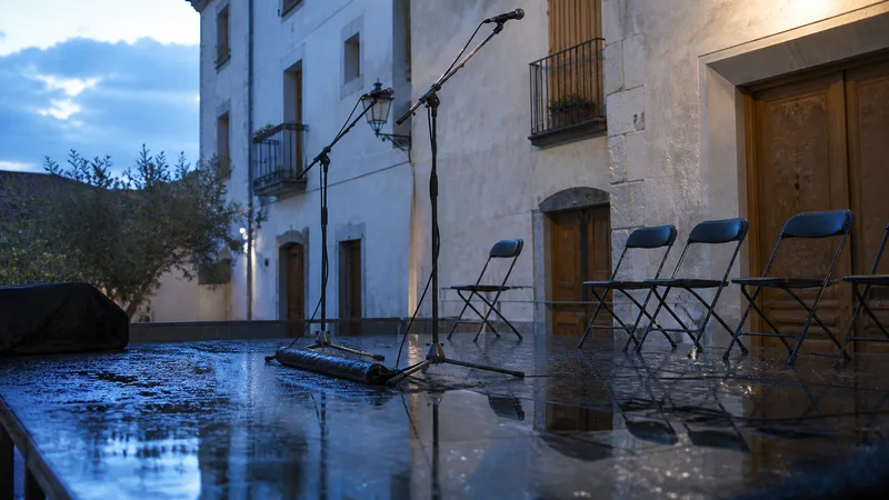 Escenario y micrófonos vacíos tras una lluvia de verano