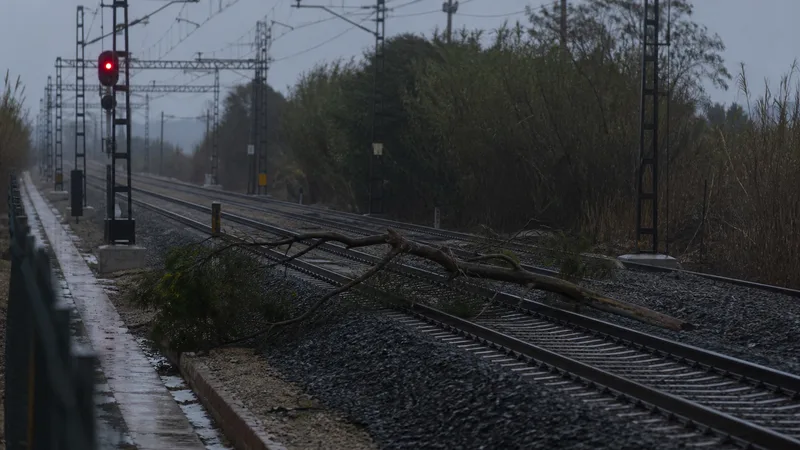 Vía ferroviaria mojada y señal roja después de una tormenta