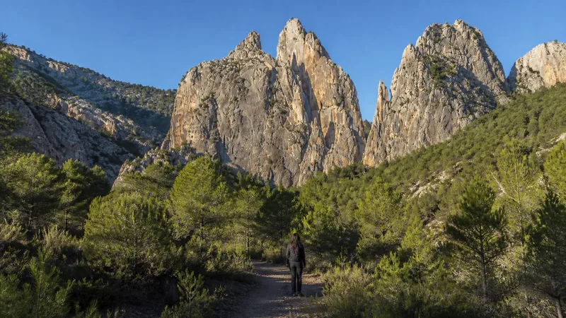 Persona diminuta ante las crestas calizas monumentales de los Cuchillos de Contreras