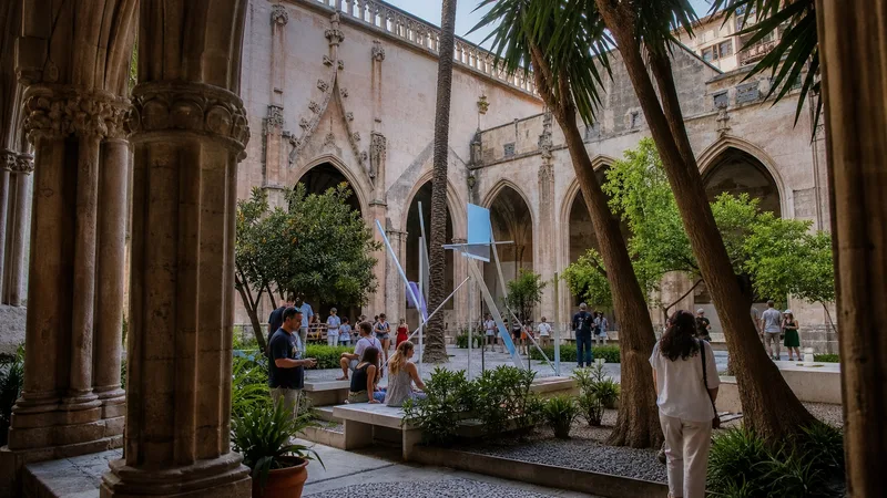 Claustro gótico del Centre del Carme con visitantes y una instalación contemporánea