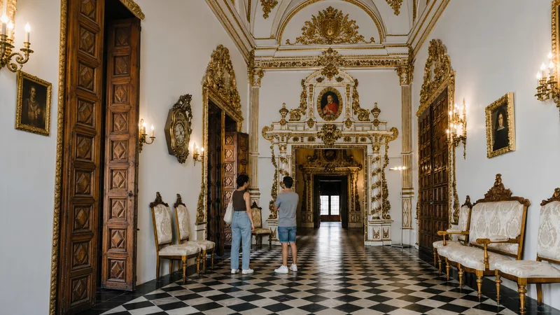 Galería Dorada con suelo ajedrezado, salones barrocos y visitantes a escala