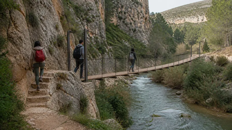 Segundo puente colgante de Chulilla junto a una senda con escalones y senderistas