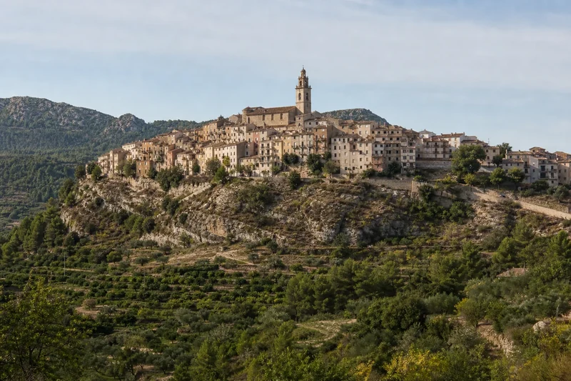 Panorámica representativa del casco histórico de Bocairent sobre una ladera rocosa, con la torre parroquial en la parte alta