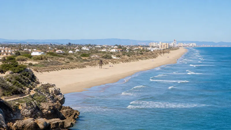 Playa del Dosel con dunas protegidas, arena, mar y Cullera al fondo