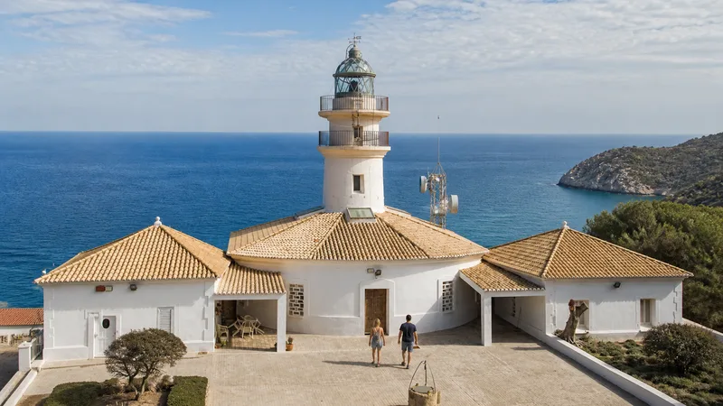 Faro de Cullera integrado en edificios blancos de teja junto al Mediterráneo