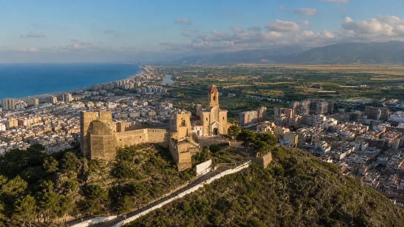 Vista elevada de Cullera con castillo, santuario, ciudad, bahía, Xúquer y arrozales