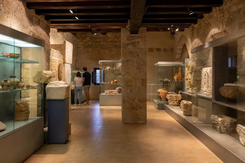 Sala del Museo Arqueológico de Sagunto con cerámica, inscripciones y fragmentos arquitectónicos