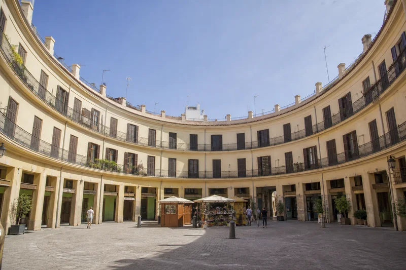Interior circular de la Plaza Redonda de València con balcones corridos y puestos centrales
