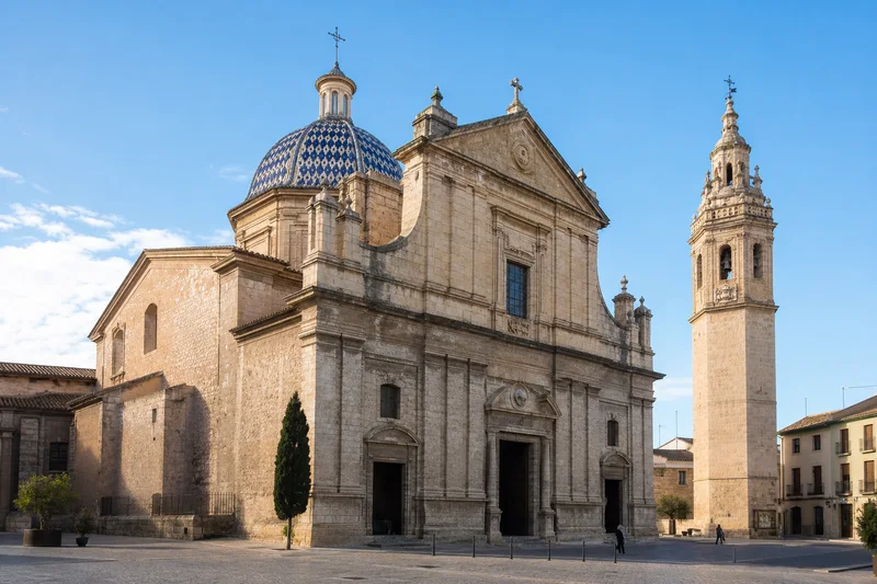 Colegiata de Santa María de Xàtiva con su fachada de piedra, cúpula de teja azul y campanario