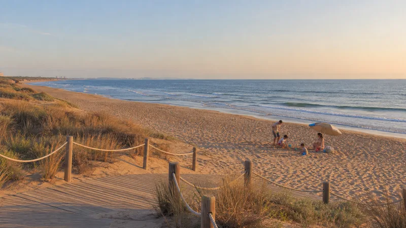 Familia jugando junto al mar en una playa natural del sur de València