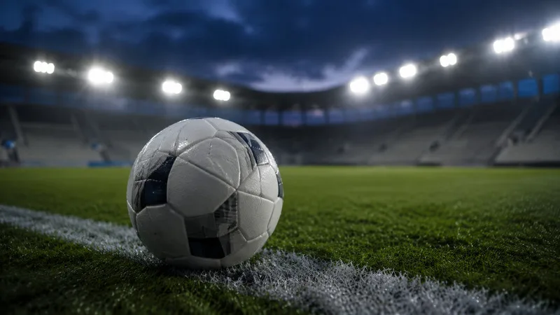 Balón de fútbol genérico sobre el césped junto a una línea blanca al anochecer